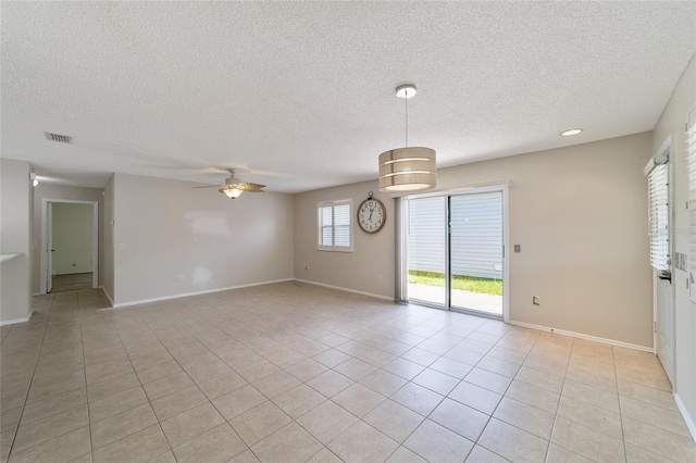 tiled empty room with ceiling fan and a textured ceiling