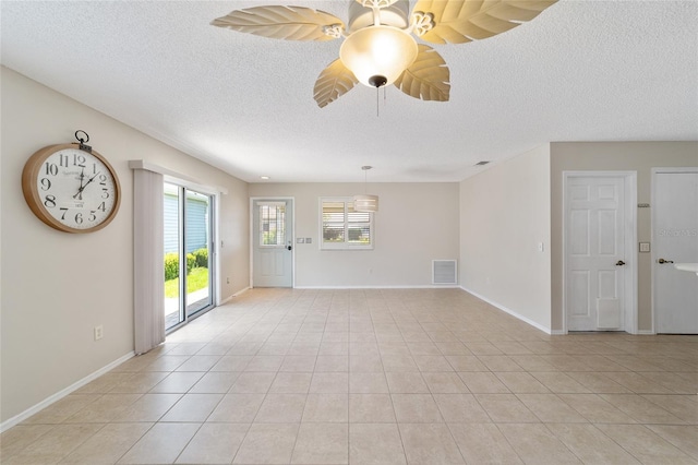 spare room featuring light tile patterned flooring and a textured ceiling