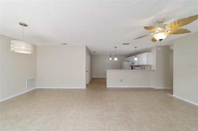 unfurnished room featuring light tile patterned floors, a textured ceiling, and ceiling fan