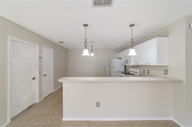 kitchen featuring kitchen peninsula, a textured ceiling, white appliances, and decorative light fixtures