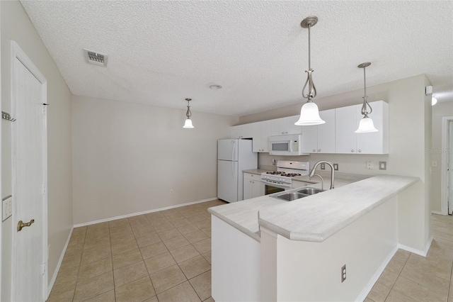 kitchen with pendant lighting, white appliances, sink, kitchen peninsula, and white cabinetry