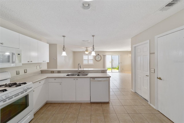 kitchen with sink, kitchen peninsula, decorative light fixtures, white appliances, and white cabinets