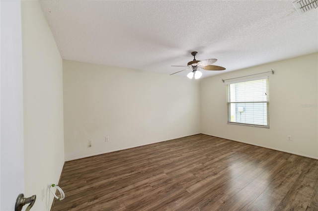 empty room featuring dark hardwood / wood-style floors, ceiling fan, and a textured ceiling