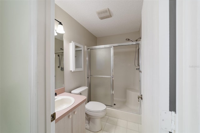 bathroom featuring tile patterned floors, a textured ceiling, toilet, a shower with door, and vanity