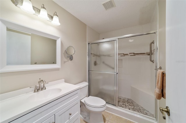 bathroom featuring walk in shower, tile patterned flooring, a textured ceiling, toilet, and vanity