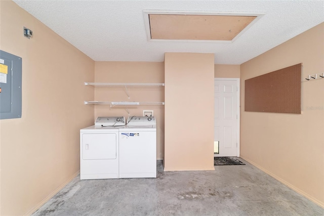 clothes washing area featuring washer and dryer, a textured ceiling, and electric panel