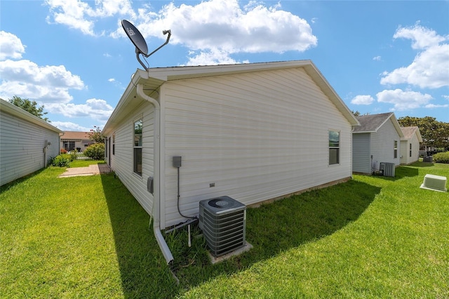 view of side of property with a yard and central AC unit