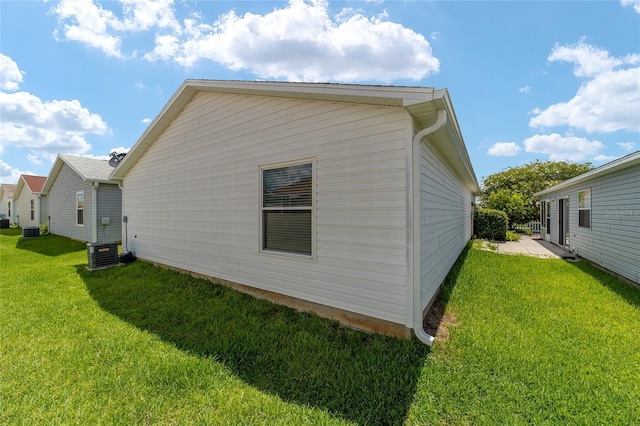 view of side of home featuring a yard and cooling unit