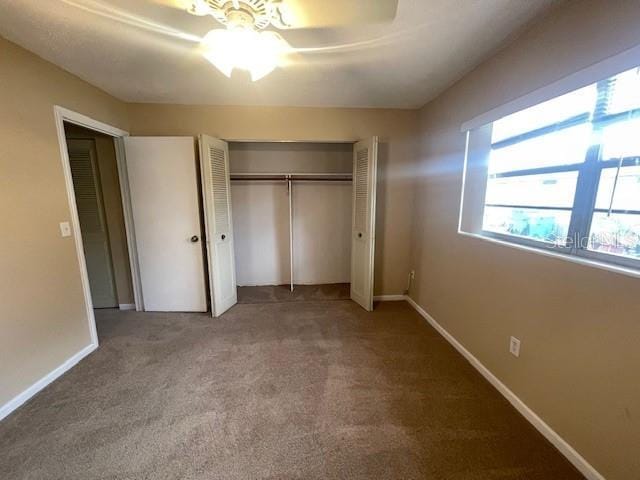 unfurnished bedroom with ceiling fan, carpet, and a closet