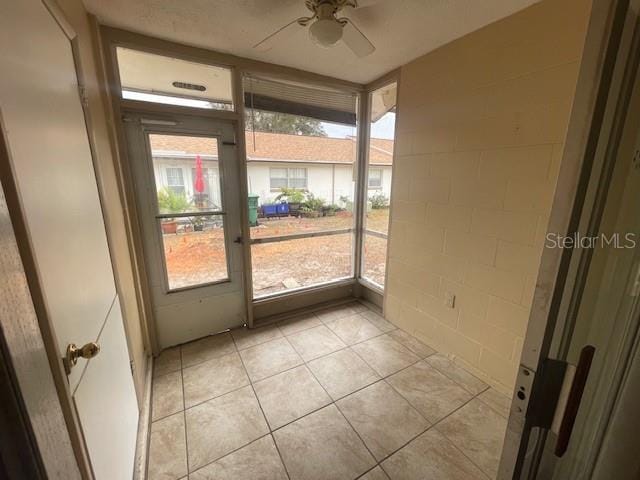 unfurnished sunroom with ceiling fan and a wealth of natural light