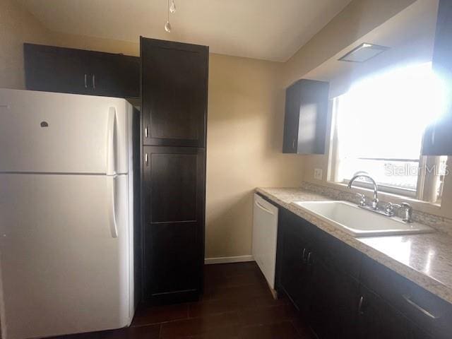 kitchen with dark wood-type flooring, sink, and white appliances