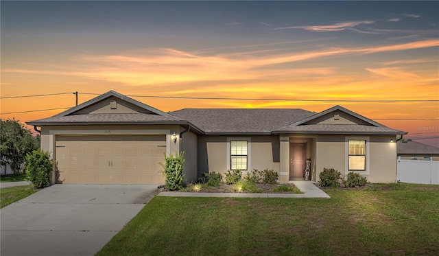 single story home with a garage and a yard