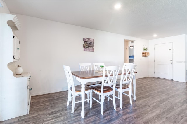 dining area featuring a textured ceiling and dark wood-type flooring