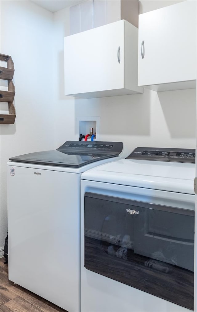 laundry area with cabinets, dark hardwood / wood-style flooring, and separate washer and dryer