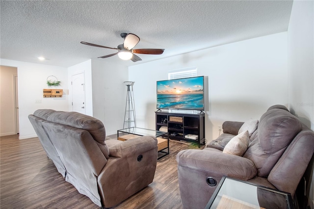 living room with ceiling fan, a textured ceiling, and dark hardwood / wood-style floors