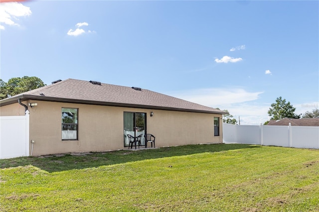 rear view of house with a yard