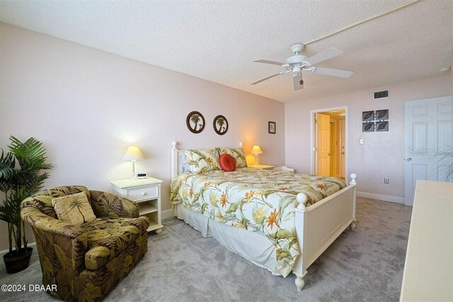 bedroom featuring carpet, a textured ceiling, and ceiling fan