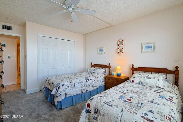 bedroom featuring a textured ceiling, a closet, carpet floors, and ceiling fan