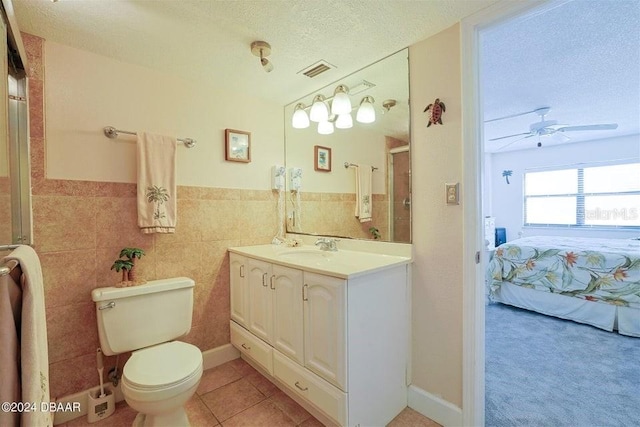 bathroom with vanity, ceiling fan, toilet, a textured ceiling, and tile patterned flooring