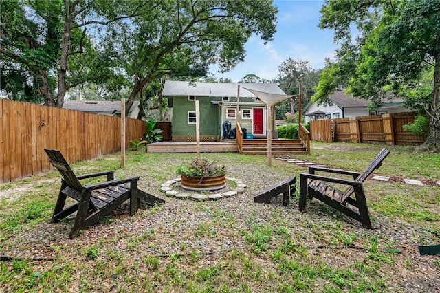 view of yard featuring a wooden deck and a fire pit