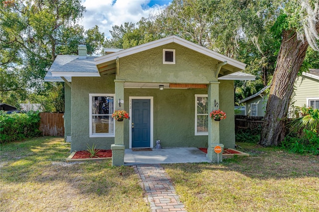 bungalow-style house featuring a front lawn