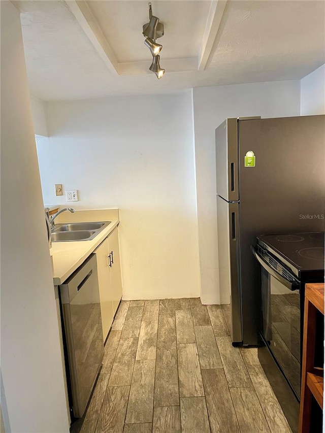 kitchen featuring black electric range, stainless steel dishwasher, sink, light hardwood / wood-style flooring, and track lighting