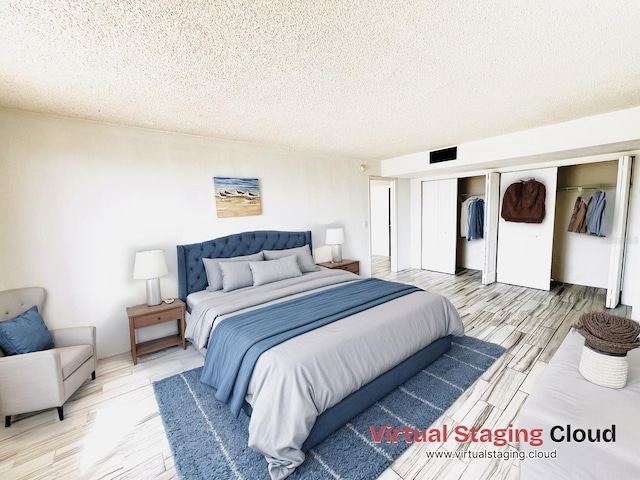 bedroom with a closet, a textured ceiling, and light wood-type flooring