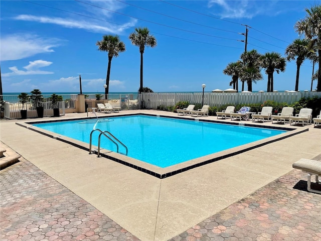 view of swimming pool with a water view and a patio area