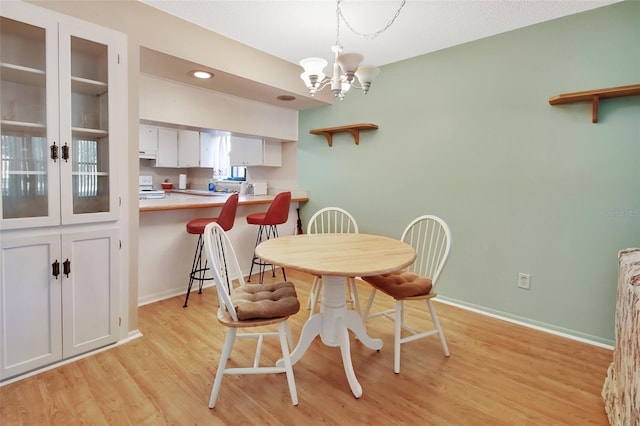 dining space featuring a notable chandelier, light hardwood / wood-style floors, and a healthy amount of sunlight