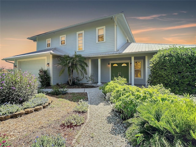 view of front of property featuring covered porch and a garage