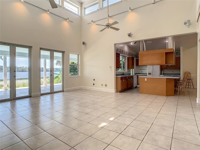 kitchen featuring ceiling fan, stainless steel appliances, french doors, a kitchen island, and a water view