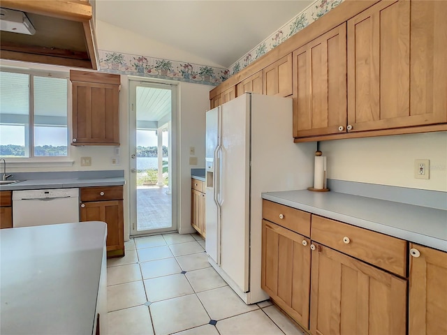 kitchen with vaulted ceiling, light tile patterned floors, and white appliances