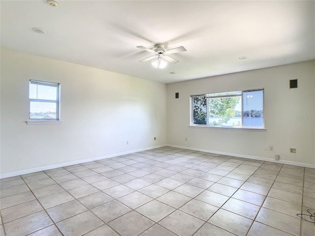 tiled spare room featuring ceiling fan