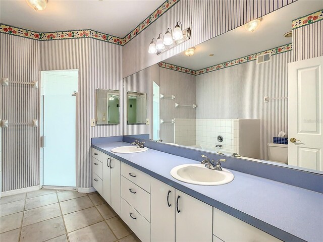 bathroom with a shower, tile patterned floors, and vanity