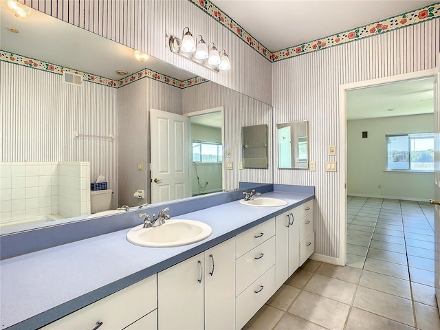 bathroom with toilet, vanity, and tile patterned flooring