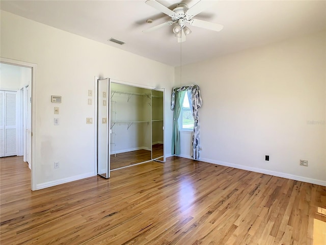 unfurnished bedroom with ceiling fan, hardwood / wood-style flooring, and a closet