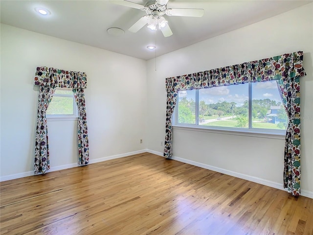 spare room with ceiling fan, plenty of natural light, and light hardwood / wood-style floors