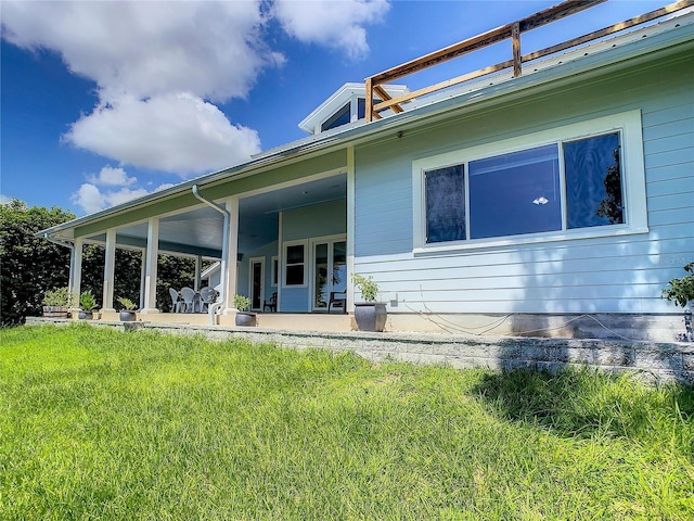 back of property with a yard and a patio