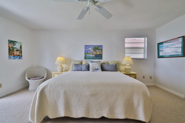 carpeted bedroom featuring ceiling fan and a textured ceiling