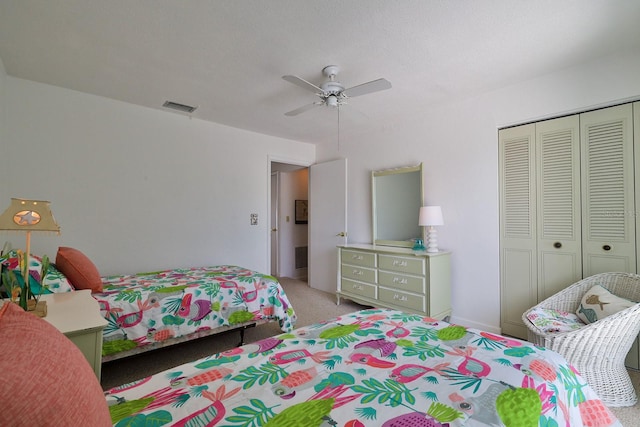 carpeted bedroom with ceiling fan and a closet