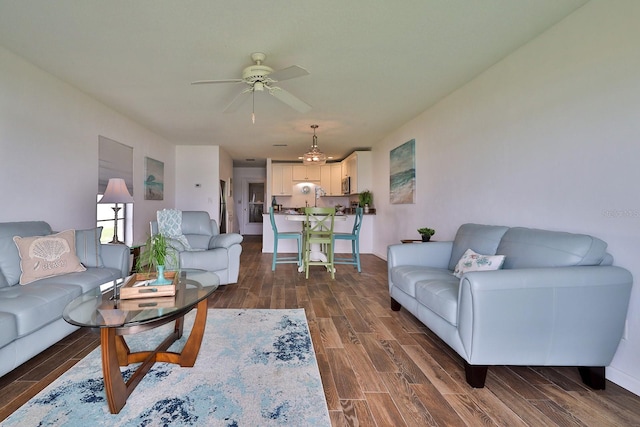 living room featuring ceiling fan and dark wood-type flooring