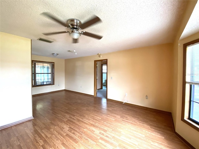 empty room with wood-type flooring, a textured ceiling, and ceiling fan