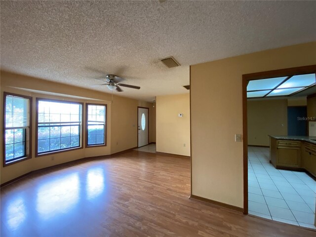 interior space with light hardwood / wood-style floors, a textured ceiling, and ceiling fan