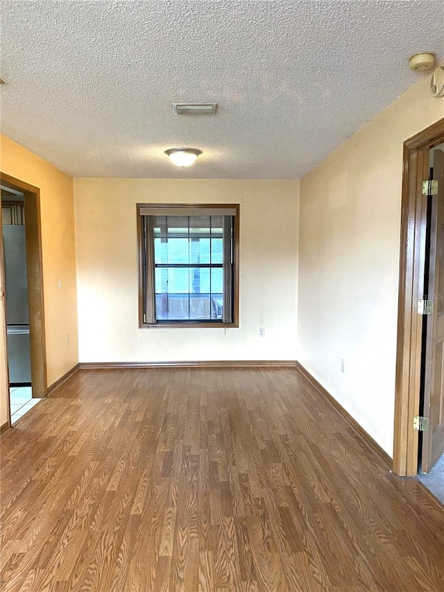 spare room with hardwood / wood-style flooring and a textured ceiling