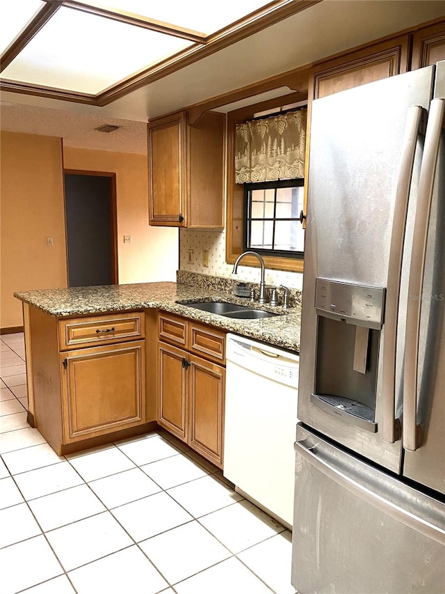 kitchen featuring white dishwasher, stainless steel refrigerator with ice dispenser, sink, kitchen peninsula, and light tile patterned flooring