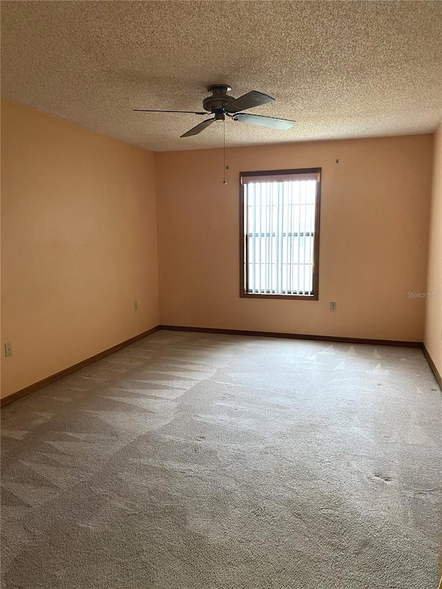 carpeted empty room featuring a textured ceiling and ceiling fan