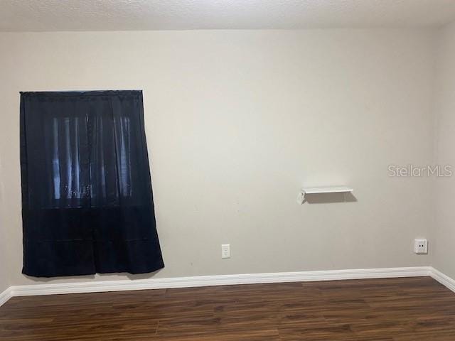 empty room with dark hardwood / wood-style floors