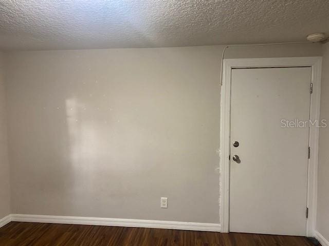 spare room with a textured ceiling and hardwood / wood-style floors