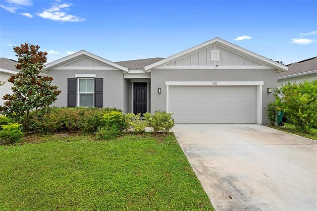 single story home featuring a garage and a front yard