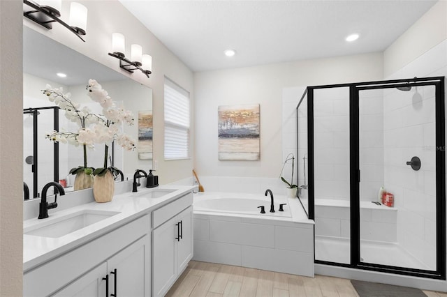 bathroom featuring vanity, wood-type flooring, and shower with separate bathtub